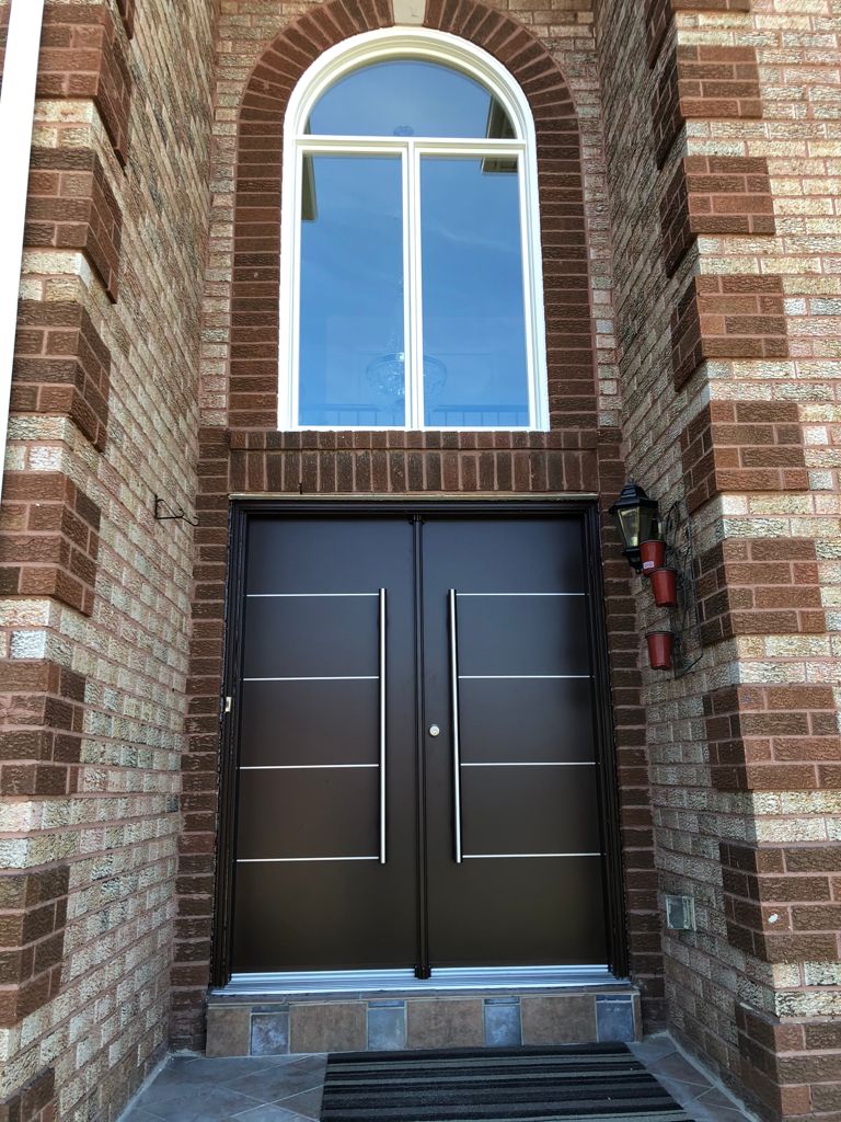 a double door set within a brick wall accompanied by a large window